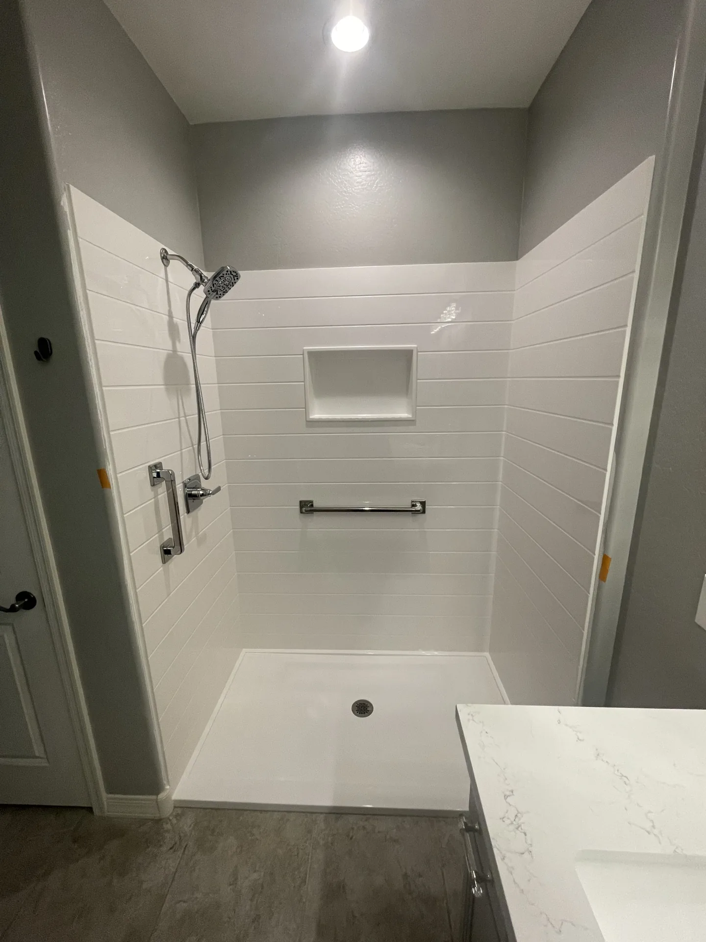 Finished walk-in shower with white shiplap-style tile and a quartz niche by Orange Cactus Remodeling, serving Scottsdale, AZ