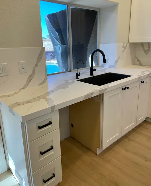 Kitchen remodel with a waterfall quartz island and custom white cabinets by Orange Cactus Remodeling — serving Mesa, AZ