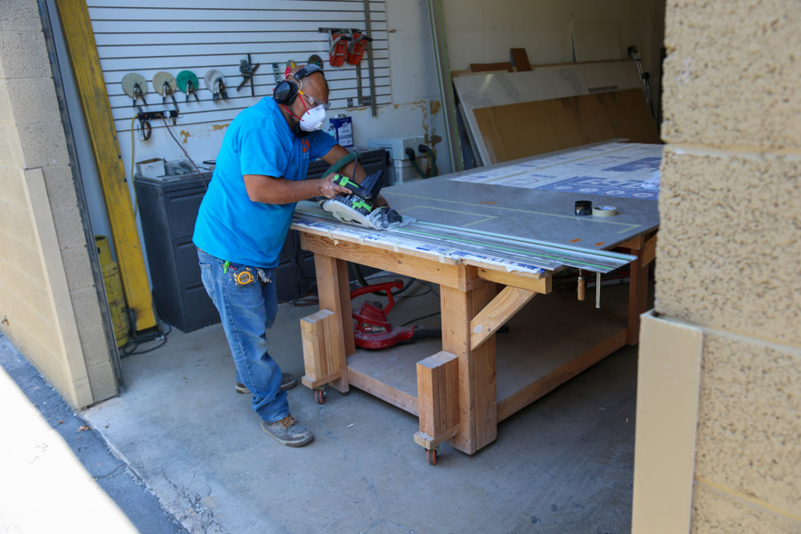 An Orange Cactus Remodeling craftsman cutting countertop material at the company's shop