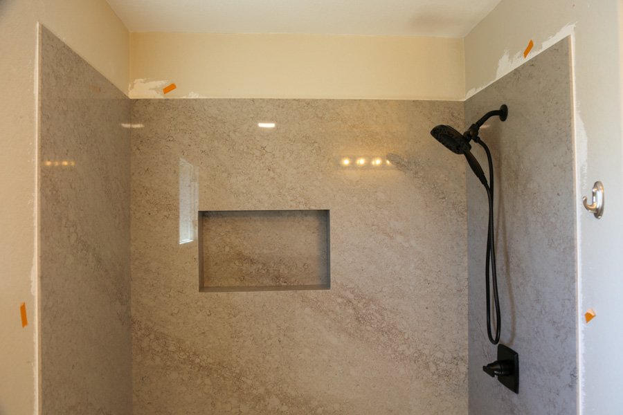 Walk-in shower with a quartz surround and recessed niche from a bathroom remodel by Orange Cactus Remodeling, serving Tempe, AZ