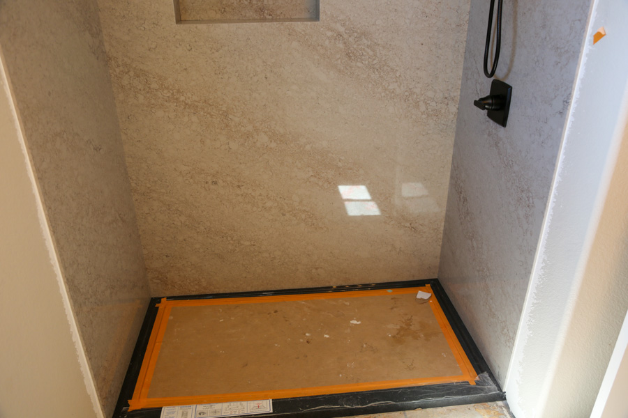 Walk-in shower with quartz-look surround walls and a matte-black fixture, remodeled by Orange Cactus Remodeling, serving Scottsdale, AZ