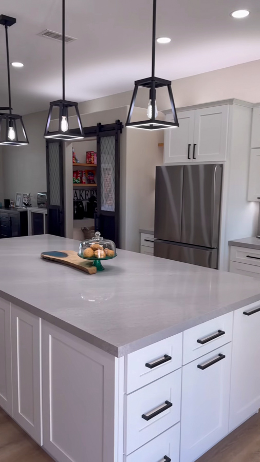 Kitchen island with pendant lighting and white cabinetry from a kitchen remodel by Orange Cactus Remodeling, serving Ahwatukee, AZ