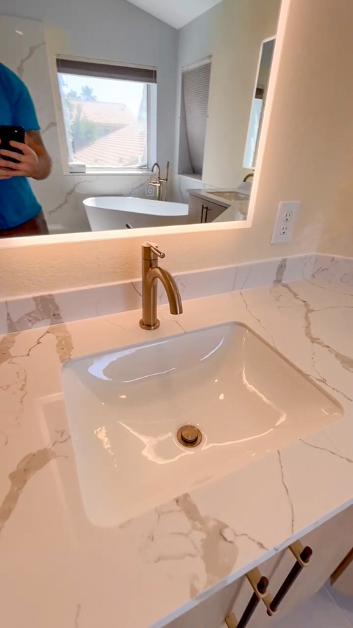 Bathroom vanity with a marble-look quartz counter, a brushed-gold faucet, and an LED mirror, remodeled by Orange Cactus Remodeling, serving Ocotillo, Chandler, AZ