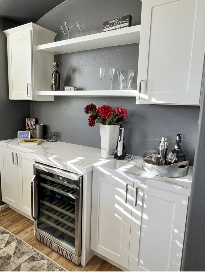 Built-in wet bar with floating shelves, marble counter, and a beverage cooler