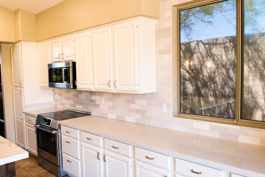 Bright kitchen remodel with white cabinets, quartz counters, and a custom tile backsplash